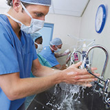 Doctors and nurses scrubbing their hands before surgery