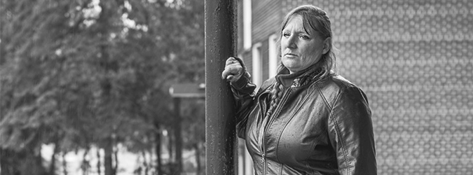 woman in a leather jacket standing on her porch