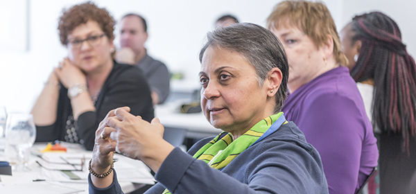 Une femme pose une question dans une réunion de participation des patients.