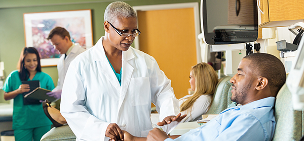 Une femme tient la main d’un patient