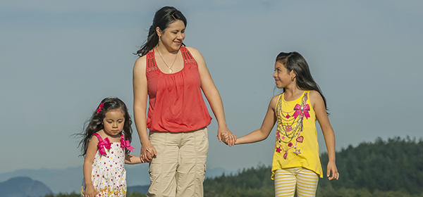 Une femme et deux petites filles se tiennent la main