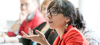 Une femme pose une question dans une réunion de participation des patients