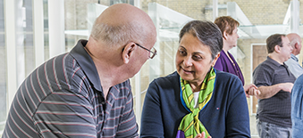 Woman and man talk during a Patient, Family and Public Advisors Council meeting