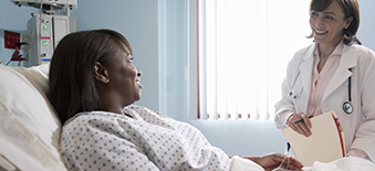 Bedridden patient in hospital talking to a doctor