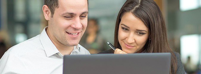 Two people looking at a computer