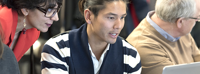 Two people working on a computer in a meeting