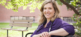 Female health care provider sitting outside on hospital grounds