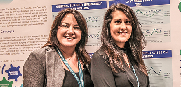 Two women smiling in front of an academic poster at the Health Quality Transformation 2015 conference. 