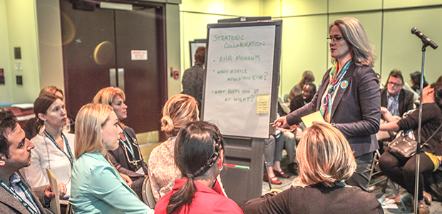 Woman speaking at a conference to a small crowd