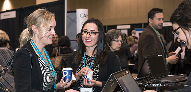 Two women standing at a computer talking