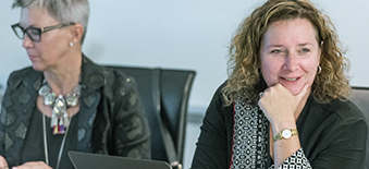 Two female OHTAC members listening to a presentation