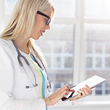 Doctor holding a touchpad checks data on patient safety in the hospital care sector in Ontario