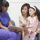 Clinician discusses document with a mother and child