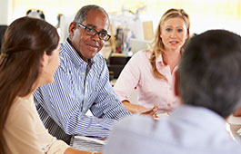 Four people discussing health quality while sitting at a round table