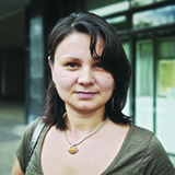 A young woman with brown hair looking at the camera