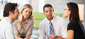 Personnes qui discutent, assises autour d'une table.