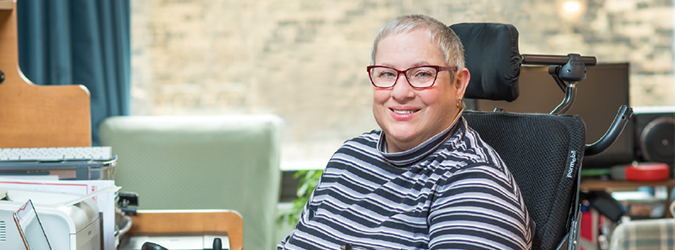 Woman sitting in a wheelchair and smiling 