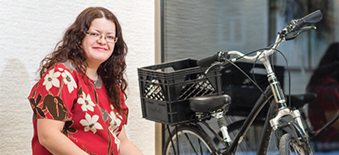 A young woman sitting next to a bicycle