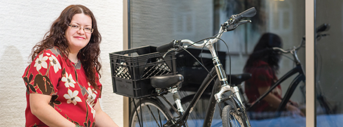 A young woman sitting next to a bicycle