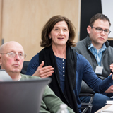 Men and women discussing health care quality at a boardroom table