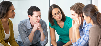 Group of young people sitting in circle while one man shares his problems