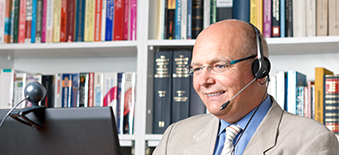 Un homme sur l'ordinateur avec son casque sur