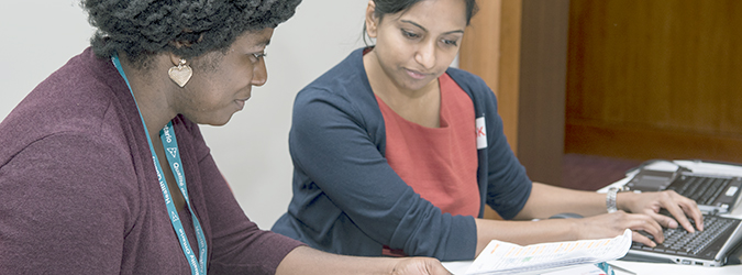 Two women reviewing resources