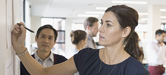 Woman drawing on a white board during meeting