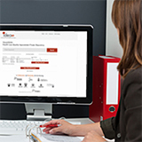 Une femme est à un ordinateur en train de consulter le répertoire en ligne de projets d'amélioration de la qualité innovants de ShareIDEAS