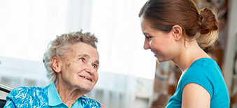 Un fournisseur de soins de santé traite une patiente âgée en fauteuil roulant