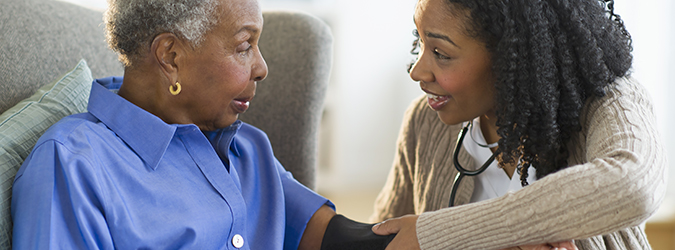 Nurse taking woman's blood pressure