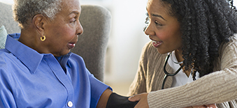 Female clinician taking blood pressure of elderly patient