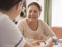 A woman is having tea with a community health worker