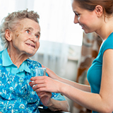 Un fournisseur de soins de santé traite une patiente âgée en fauteuil roulant.