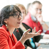 A woman asking a question in a patient engagement meeting