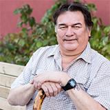 A male patient sitting on a park bench