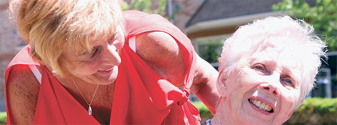 a woman pushing her mother in a wheelchair