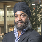 A man wearing a turban standing outside a hospital