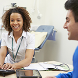 Two health care professionals searching for system performance information on a computer in a hospital office