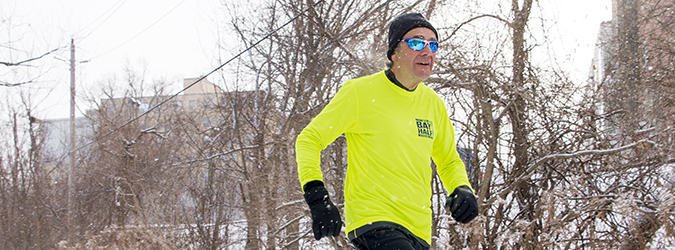 man running outdoors through a forest in the winter 