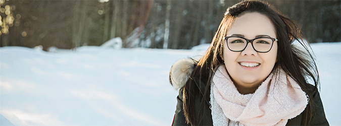 Young woman who shared her experience about health care in Northern Ontario in snowy landscape near her home in Moose Factory