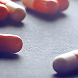 Photo of red and white pill capsules on a table 